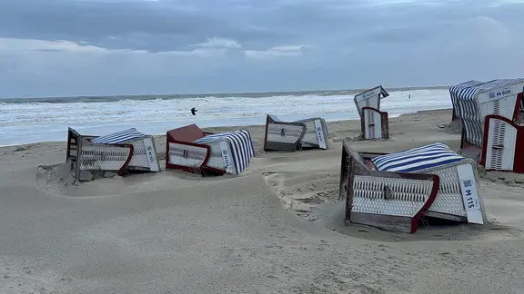 Umgestürzte Strandkörbe liegen am Strand von Norderney.