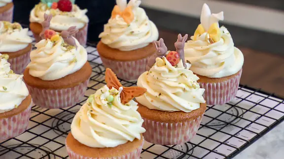 Auf einem Gitter stehen mehrere österlich dekorierte Cupcakes. | NDR Auf einem Gitter stehen mehrere österlich dekorierte Cupcakes.