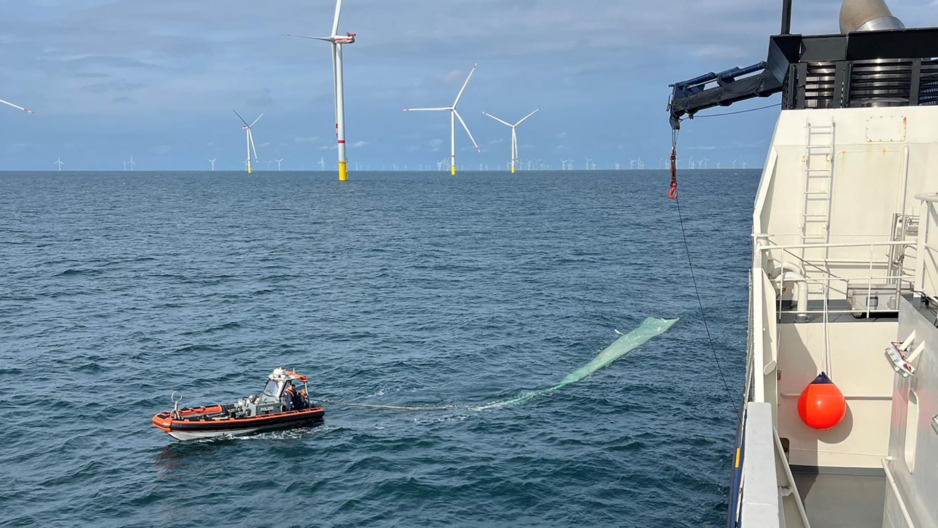 Ein Motorboot zieht das Rotoblatt eines Windrads durchs Wasser der Nordsee. | Bundespolizeiinspektion See Cuxhaven
