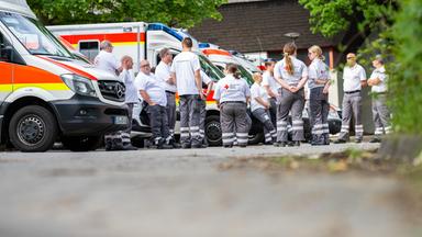 Sanitäter vom Deutschen Roten Kreuz stehen am Evakuierungszentrum in Osnabrück