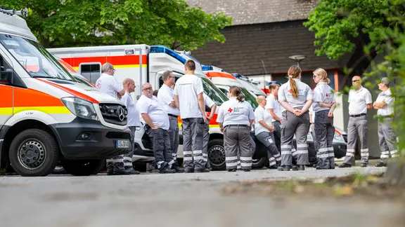 Sanitäter vom Deutschen Roten Kreuz stehen am Evakuierungszentrum in Osnabrück