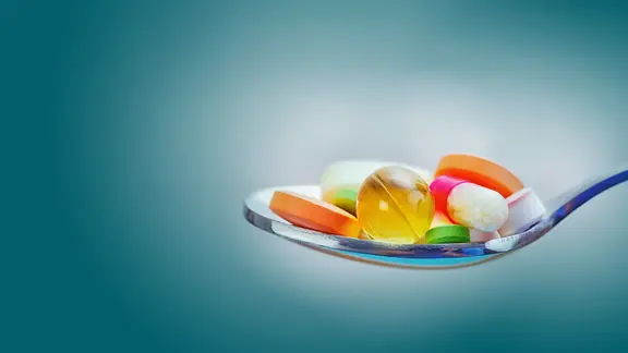 Ein Löffel mit verschiedenen bunten Pillen