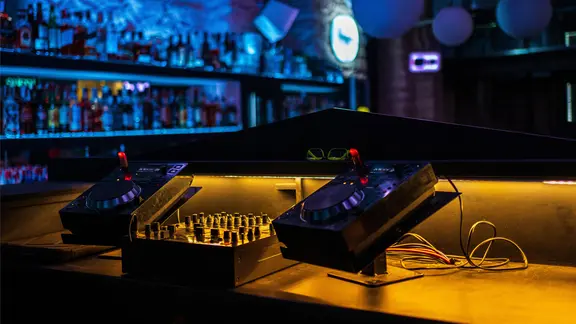 Ein DJ-Mischpult steht in einem Club.