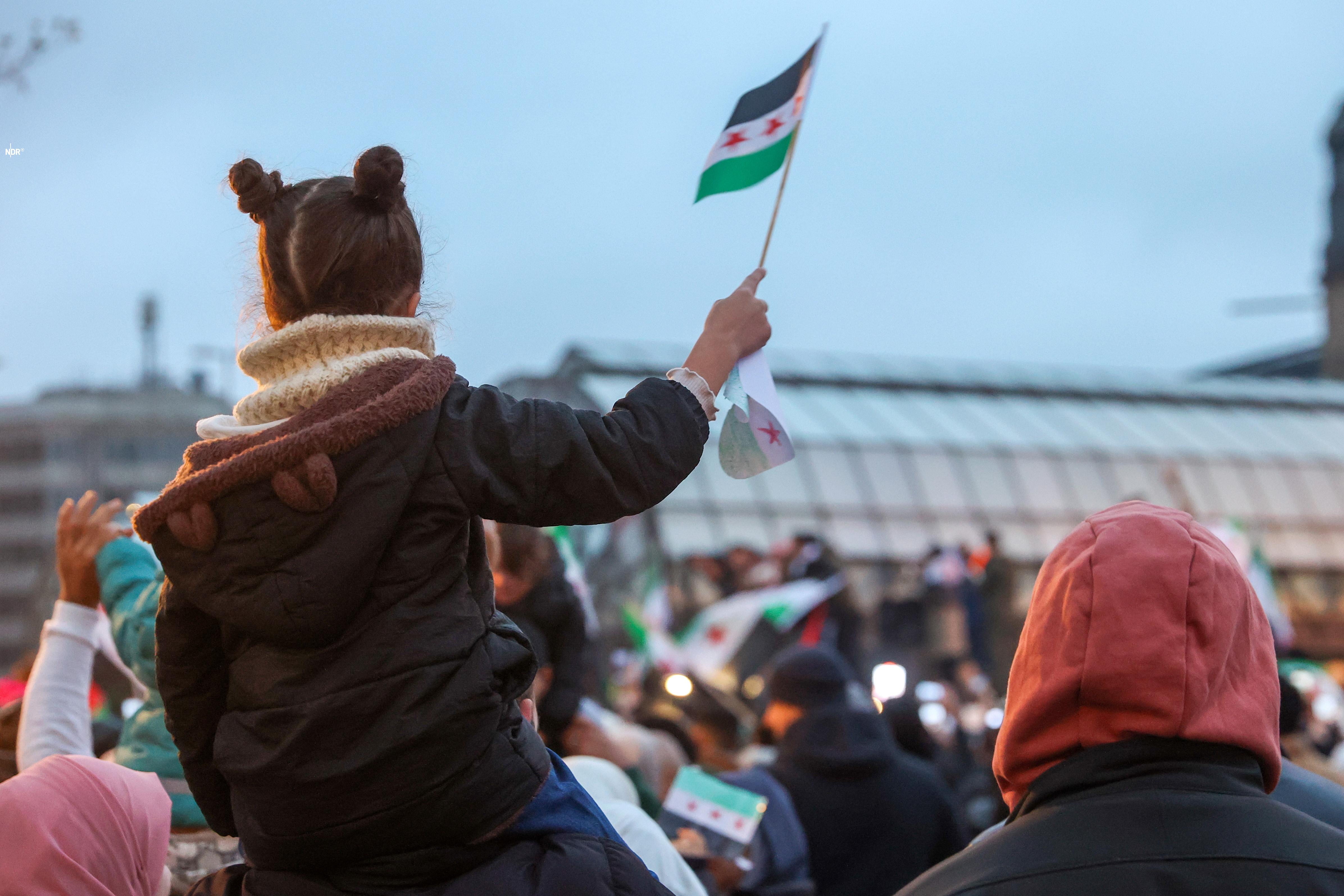 Zahlreiche Menschen feiern am Hachmannplatz am Hauptbahnhof den Sturz von Syriens Machthaber Assad.