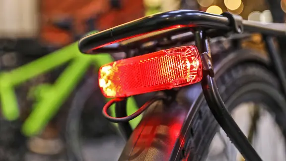 The rear light of a bicycle is illuminated.