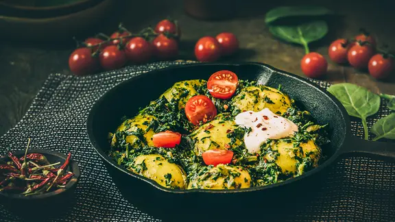 In einer Pfanne ist ein Spinatgericht mit pochiertem Ei angerichtet.