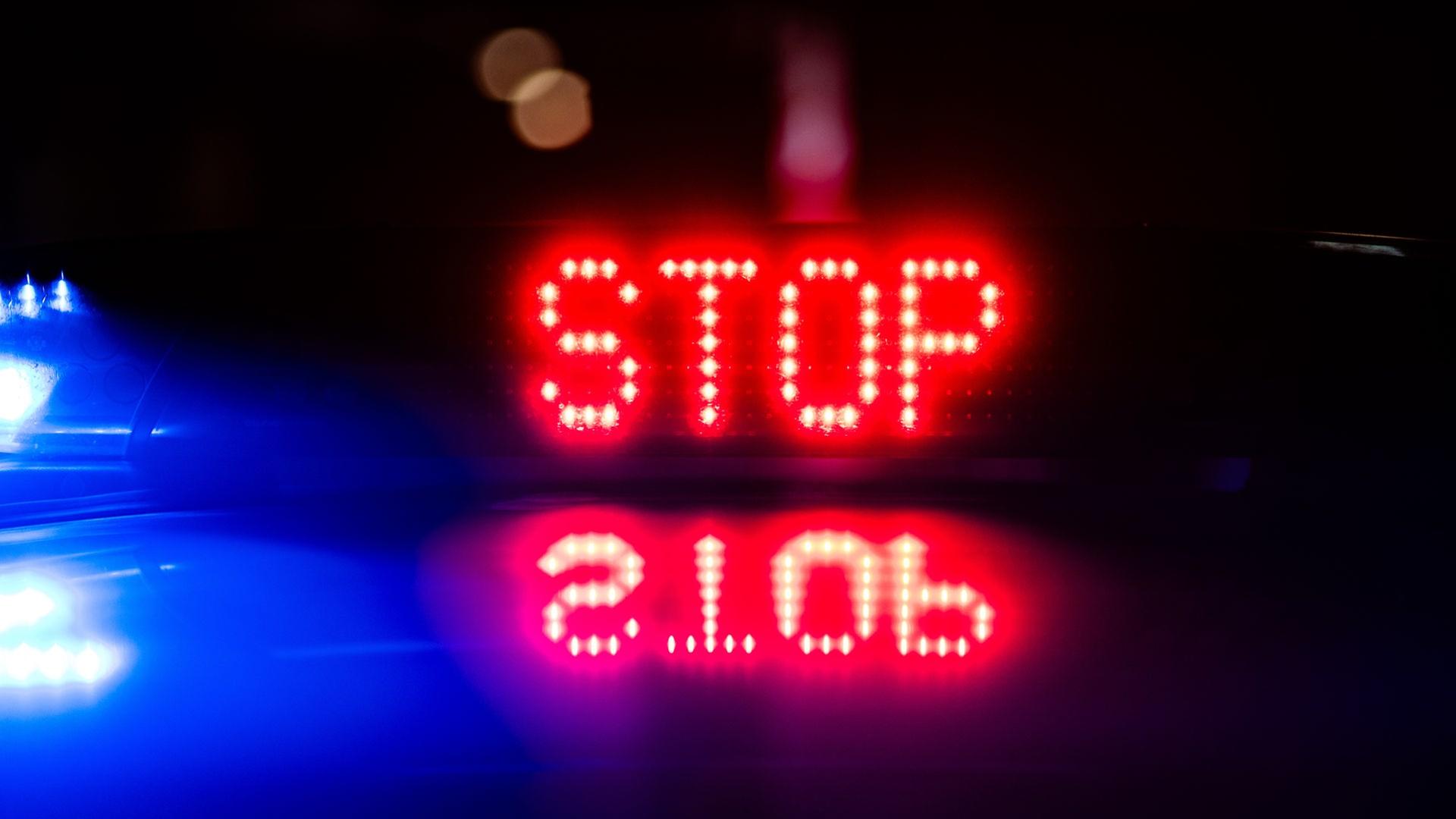 „Stop“ ist auf dem Dach eines Polizeiautos zu lesen. | picture alliance/dpa, Robert Michael