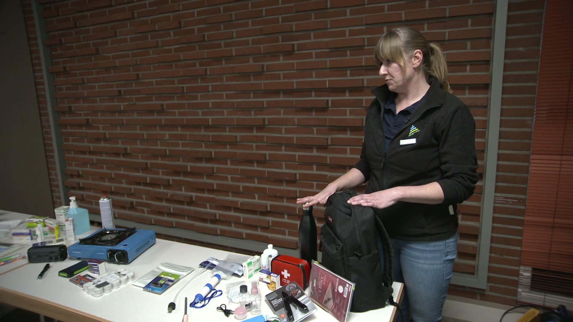 Eine Zivilschützerin steht vor einem Tisch. Darauf stehen Utensilien, die für den Krisenfall wichtig sind. | NDR