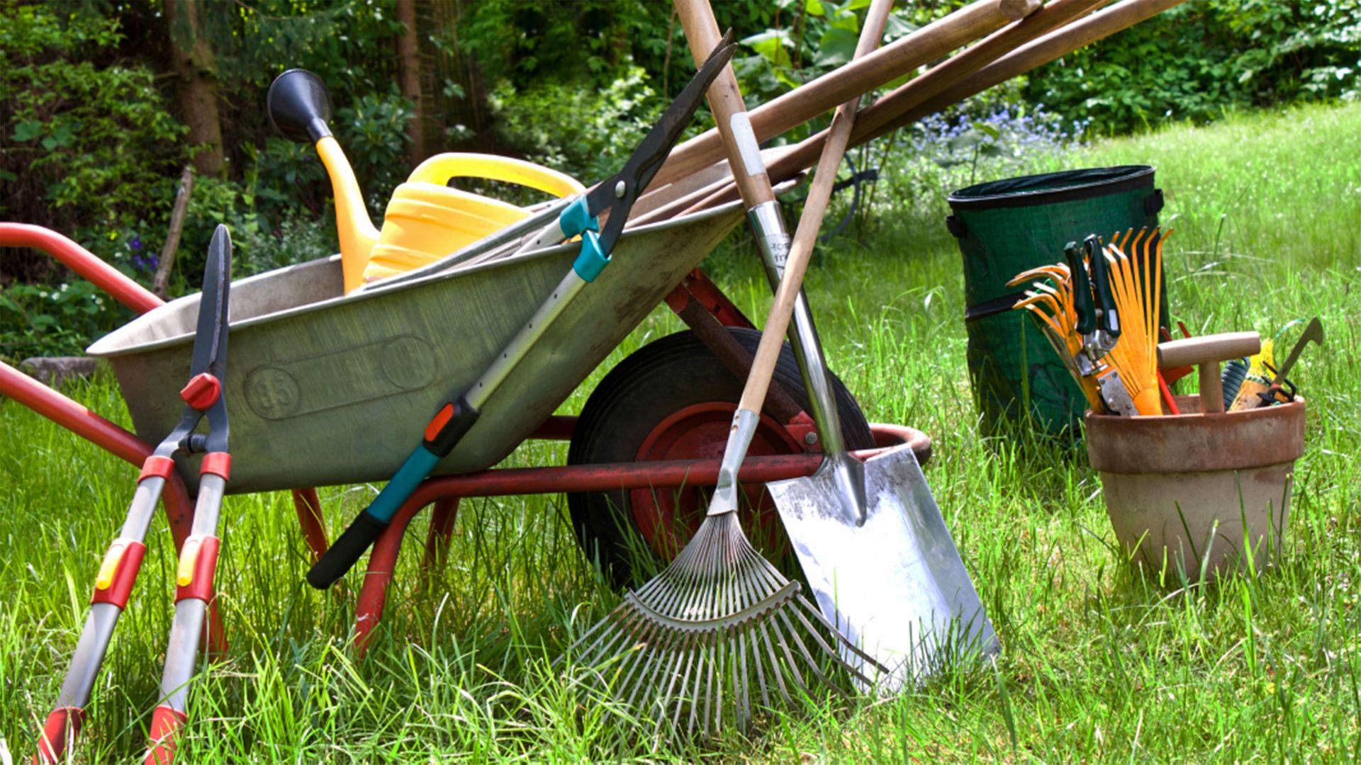 Verschiedene Gartengeräte in und neben einer Schubkarre. | fotolia, PhotoSG