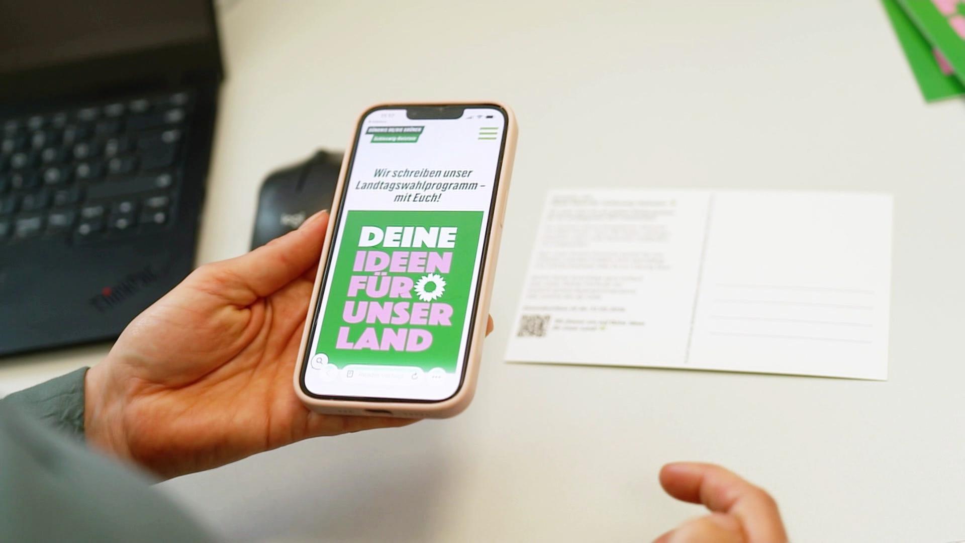 Eine Person hält ein Smartphone in der Hand. | Screenshot