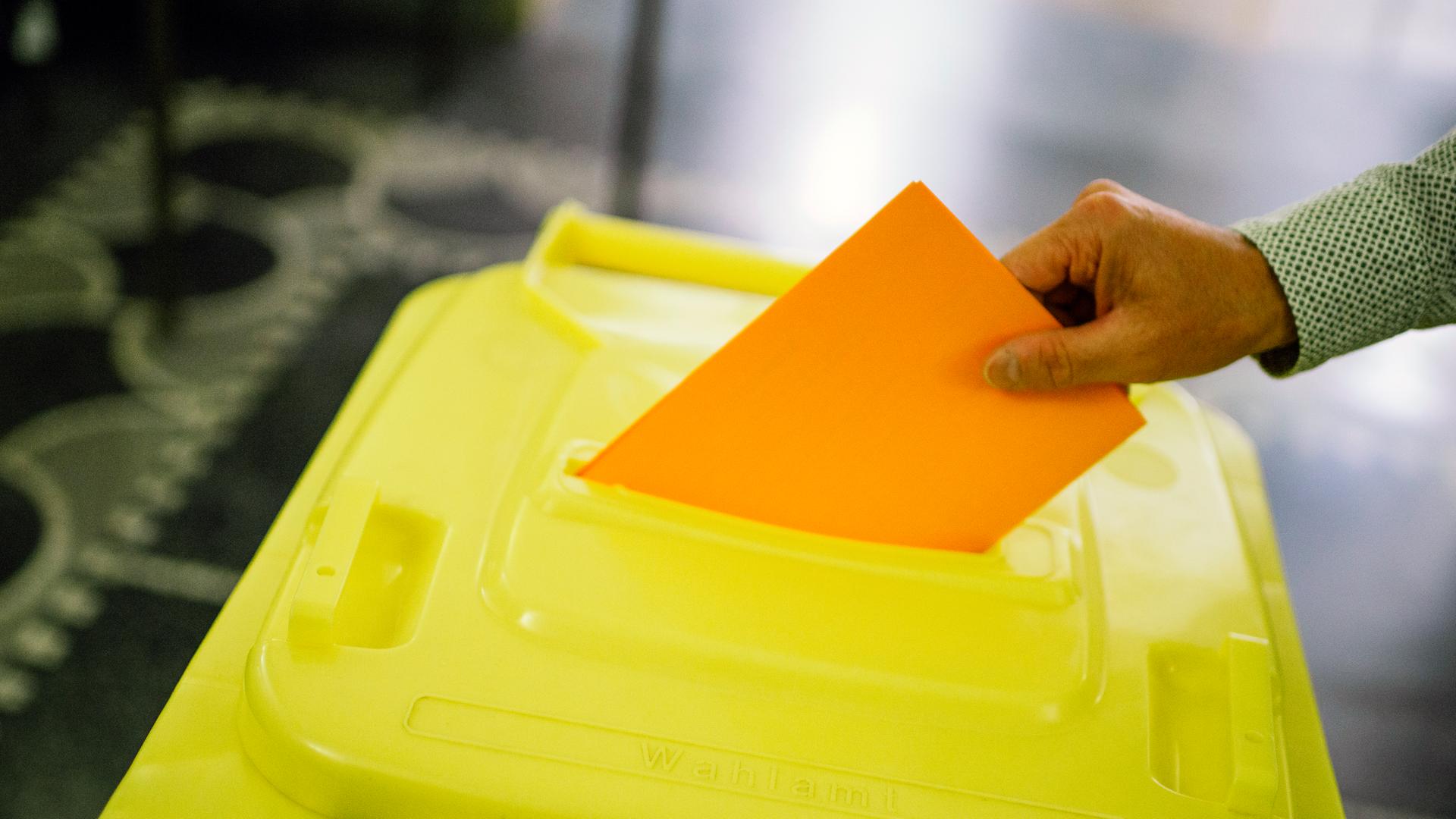 Ein Mann wirft einen Stimmzettel in eine Wahlurne. | Julius Matuschik