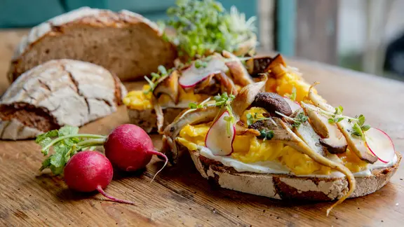 Käse-Rührei mit Pilzen auf Brot serviert