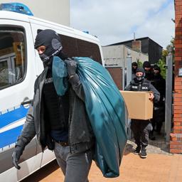 Nach den Durchsuchungen von Räumen im Gebäude "Altes Postamt" kommen die Ermittler mit beschlagnahmtem Material aus dem Haus.
