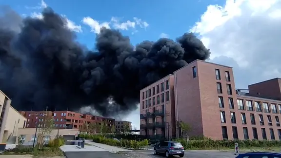 Schwarzer Rauch steigt über brennenden Baustoffen in Hannover.